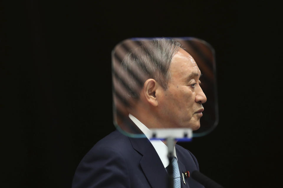 FILE - In this Sept. 9, 2021, file photo, Japanese Prime Minister Yoshihide Suga is seen through a teleprompter as he speaks during his news conference at his office in Tokyo. The stakes are high as Japanese governing party members vote Wednesday, Sept. 29, 2021 for four candidates seeking to replace Suga as prime minister. The next leader must address a pandemic-battered economy, a newly empowered military operating in a dangerous neighborhood, crucial ties with an inward-focused ally, Washington, and tense security standoffs with an emboldened China and its ally North Korea. (Kim Kyung-Hoon/Pool Photo via AP, File)