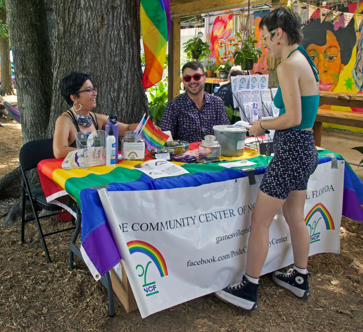 Shiala Narago, left, and Ike Reichenbach, middle, volunteers with the Pride Community Center of North Central Florida, talk with Hayla Corzine, right, about the next Queer Maker's Market while at the 4th Ave Food Park in Gainesville on Saturday. The next Queer Maker’s Market will be held at Heartwood Soundstage on June 26, and will be co-sponsored by the Pride Community Center of North Central Florida. “Pride Center will be expanding our open hours later this summer, and we invite everybody to the pride festival on Oct. 22,” said Faith Reidenbach, the center's volunteer coordinator.