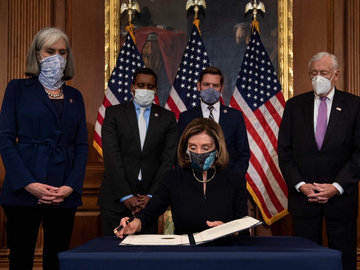 <p>Majority Leader Steny Hoyer (D-MD) (R) and Assistant Speaker Katherine Clark (D-MA) (L), alongside House Impeachment Managers (from L) Representatives Joe Neguse (D-CO) and Eric Swalwell (D-CA), look on as Speaker of the House Nancy Pelosi (D-CA) prepares to sign the article of impeachment during an engrossment ceremony after the US House of Representatives voted to impeach the US President Donald Trump at the US Capitol on 13 January 2021, in Washington, DC</p> ((AFP via Getty Images))