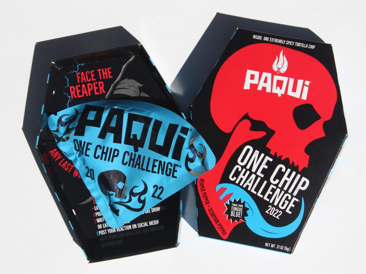 The Paqui 'one chip challenge' tortilla chip in its red, black and blue coffin-shaped box, decorated with a skull.