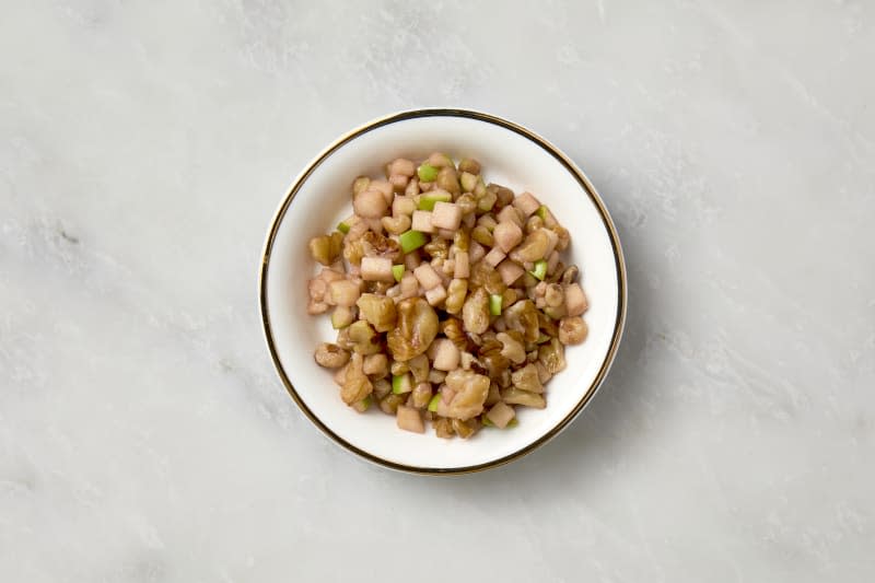 overhead shot of charoset in a small white plate with a gold rim.