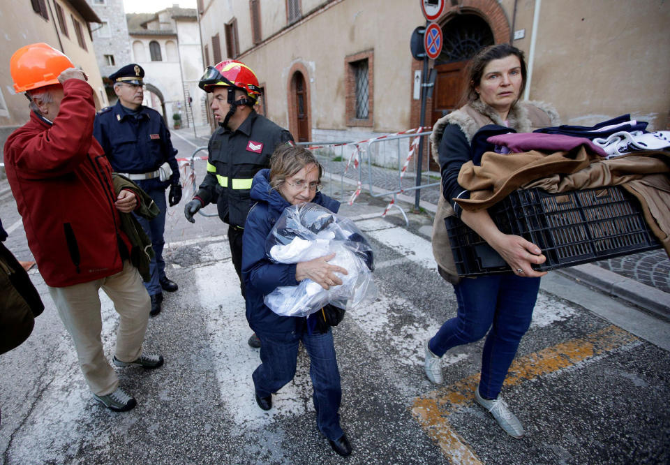 Two women carry their belongings