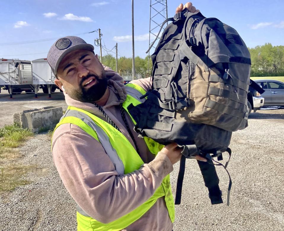 Dairon Socarras Quintero, 32, shows the dust collected on the backpack he had inside his company's truck at the time of the dust storm, even though his cabin is completely closed up, Monday, May 1, 2023, in Divernon, Ill. Socarras was driving a 16 foot truck for his elk Grove Village based company that does custom picture framing he was on his way to St. Louis to make deliveries. (AP Photo/John O'Connor)