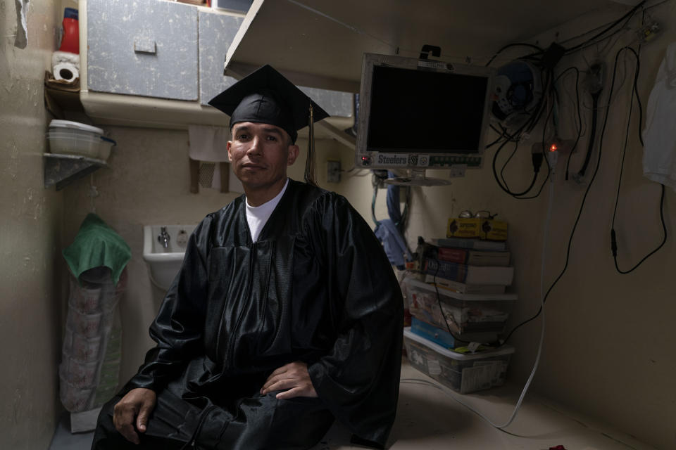 Jose Catalan, who earned a bachelor's degree in communications through the Transforming Outcomes Project at Sacramento State (TOPSS), sits for a portrait in his cell after a graduation ceremony at Folsom State Prison in Folsom, Calif., Thursday, May 25, 2023. (AP Photo/Jae C. Hong)