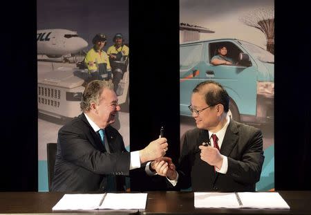 Toll Holdings Ltd Chairman Ray Horsburgh (L) and Japan Post Chief Executive Toru Takahashi exchange a pen during an official signing ceremony in Sydney February 18, 2015. REUTERS/Jeremy Piper/Oculi