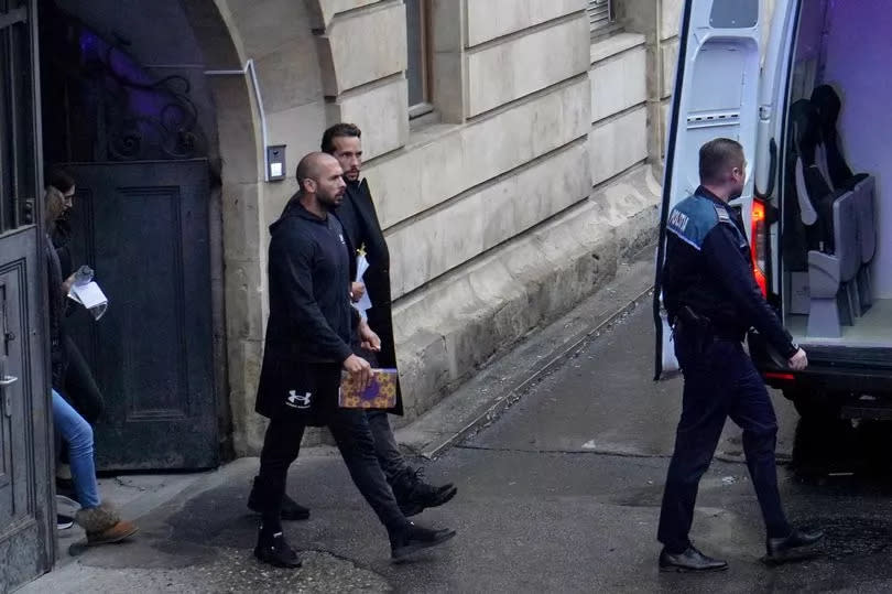 Andrew Tate (L) and Tristan Tate leave the Bucharest Court of Appeal after the hearing