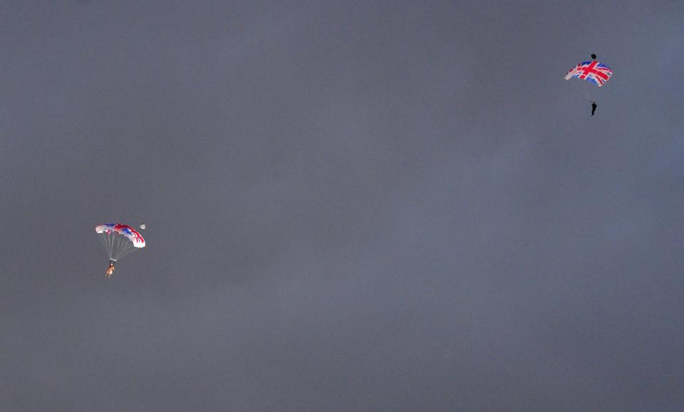 <p>Skydivers dressed as Queen Elizabeth II (left) and James Bond (right) parachuted over the Opening Ceremony arena in London. (AP) </p>