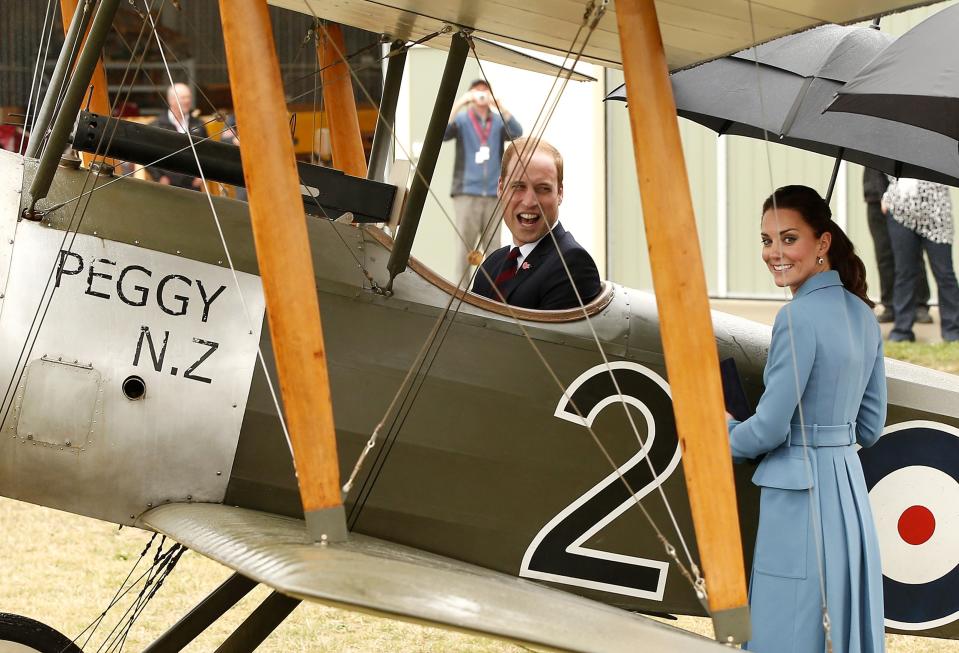 Britain's Prince William laughs as his wife, Catherine, the Duchess of Cambridge, stands next to a Sopwith Pup vintage plane he is sitting in near Blenheim