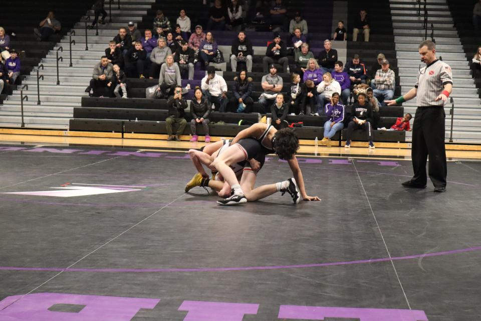 Liberty's Tian Phem attempting to take down Cedar Falls' Brayden Wiles.