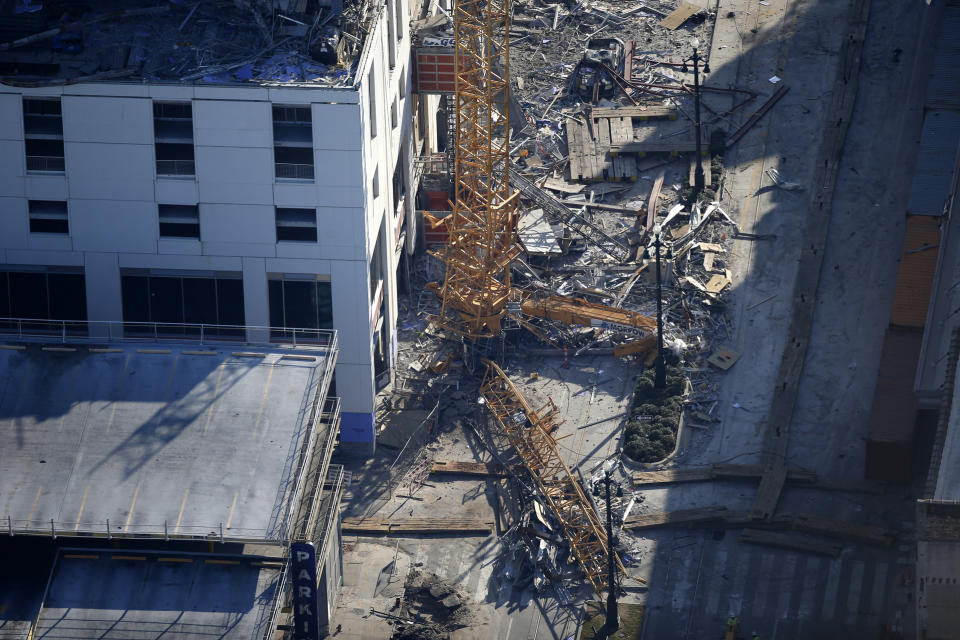 One of two large cranes from the Hard Rock Hotel construction collapse is seen on Rampart Street, after crashing down, after being detonated for implosion in New Orleans, Sunday, Oct. 20, 2019. (AP Photo/Gerald Herbert)