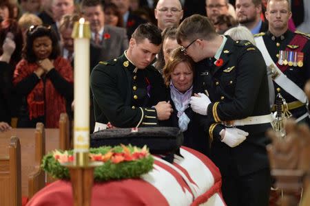 Kathy Cirillo is comforted in front of the coffin of her son Cpl. Nathan Cirillo at his regimental funeral service in Hamilton, Ontario October 28, 2014. REUTERS/Nathan Denette/Pool