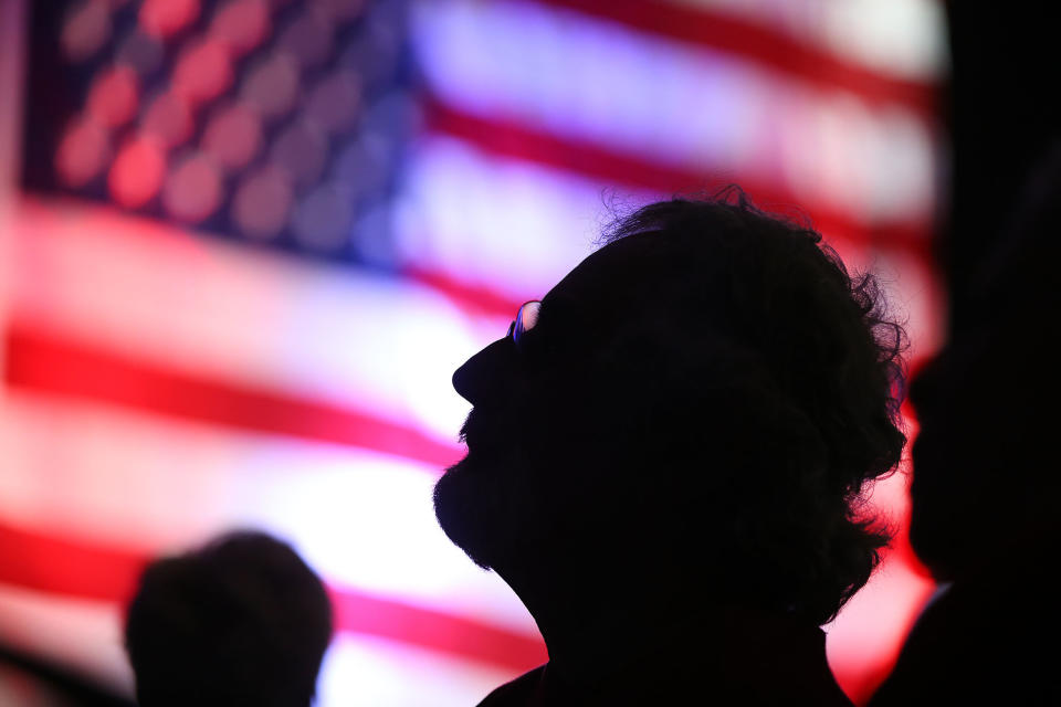 A man watches the election results on a giant television at an election night watch party for Donald Trump supporters at the F1 indoor care racetrack ballroom in Braintree, Massachusetts, on Nov. 8, 2016.