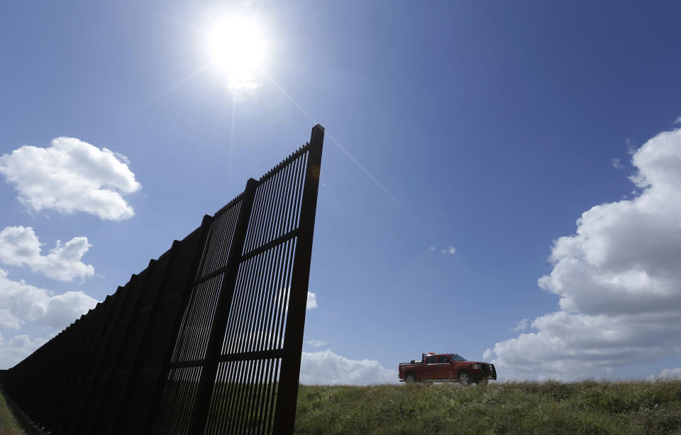 In this Sept. 6, 2012, photo, cotton farmer Teofilo “Junior” Flores drives his truck along the U.S.-Mexico border fence that passes through his property in Brownsville, Texas. Since 2008, hundreds of landowners on the border have sought fair prices for property that was condemned to make way for the fence, but many of them received initial offers that were far below market value. (AP Photo/Eric Gay)