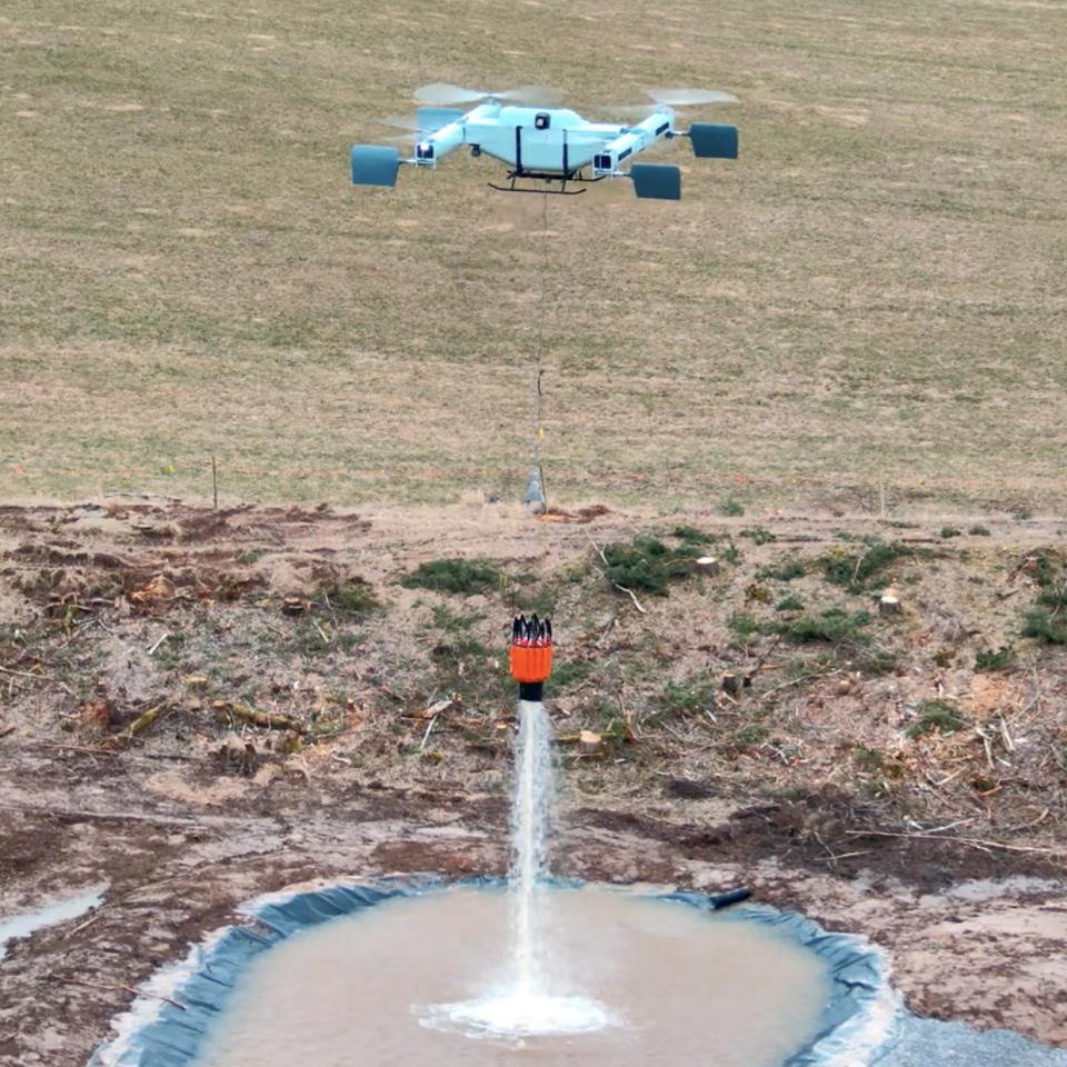 The FireSwarm command Thunderwasp Heavy-Lift Drone buckets liquid with job fourpenny Bambi Bucket during effort flight.