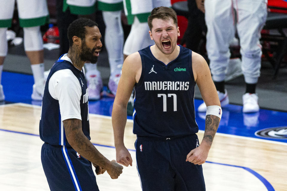 Dallas Mavericks guard Luka Doncic (77) celebrates with teammate James Johnson (16) after making a 3-point basket during the second half of an NBA basketball game against the Boston Celtics in Dallas, Tuesday, Feb. 23, 2021. (AP Photo/Sam Hodde)