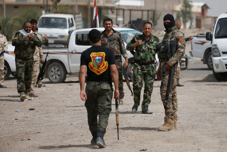 Members of the Shi'ite Badr Organisation walk with their weapons in Saqlawiya, north of Falluja, Iraq, June 5, 2016. REUTERS/Thaier Al-Sudani