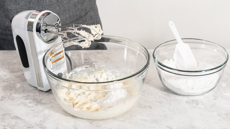 hand mixing powdered sugar into cream cheese frosting