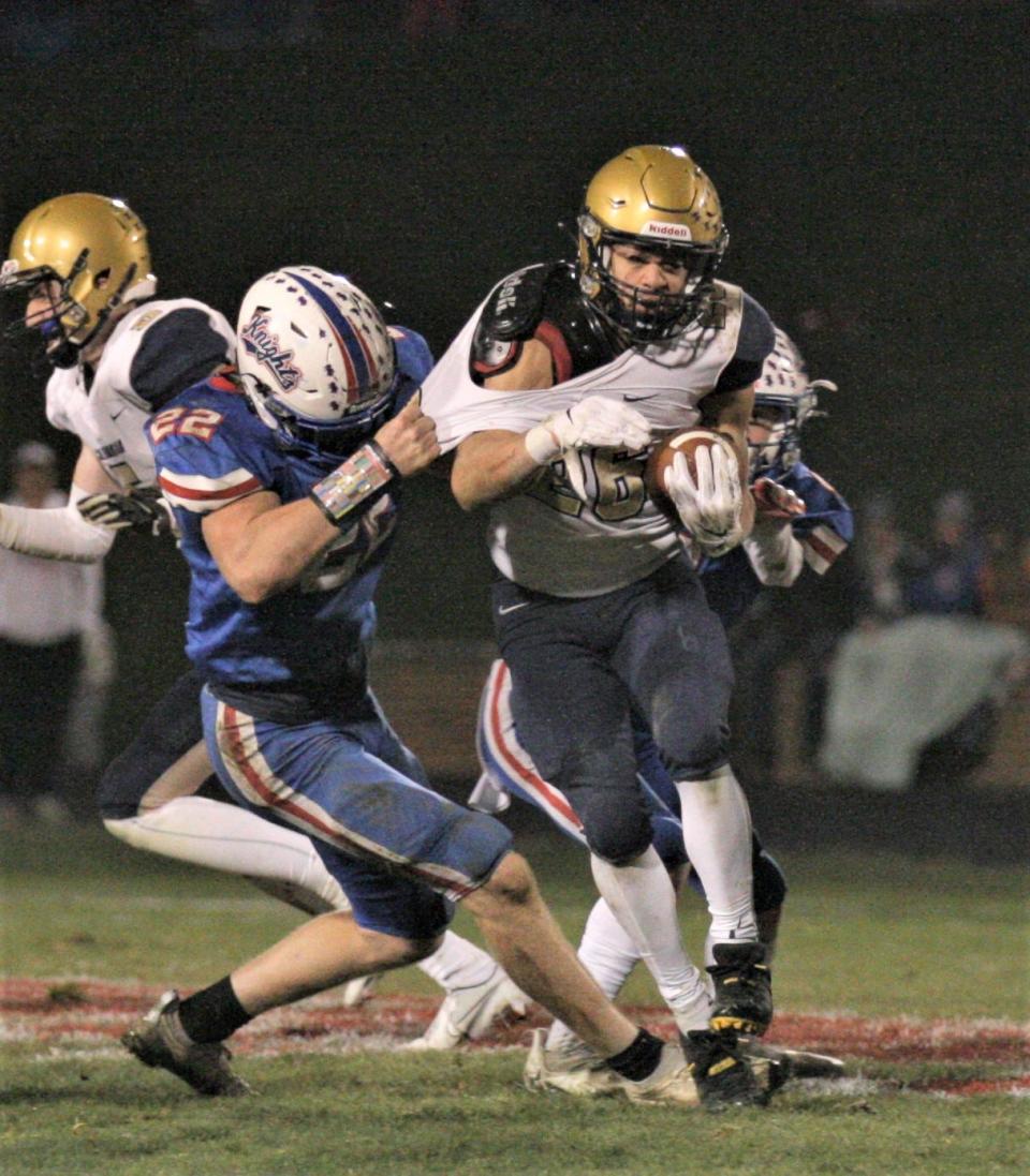 Elisha Baldridge (22) and another West Holmes defender try to bring down Tornado running back Damian Brockington.