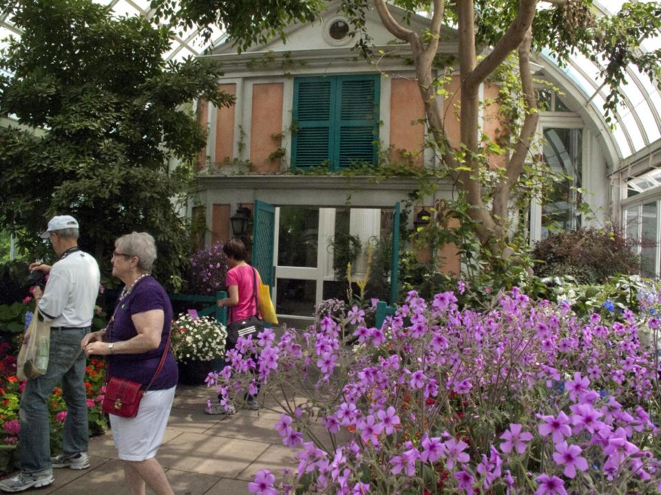 In this May 26, 2012 photo, a replica of the facade of French impressionist artist Claude Monet’s pink stucco house is featured in an exhibition at the New York Botanical Garden in New York. “Monet’s Garden,” evokes the artist’s garden at Giverny, his home in France from 1883 until his death in 1926. It runs through Oct. 21. (AP Photo/Ray Stubblebine)