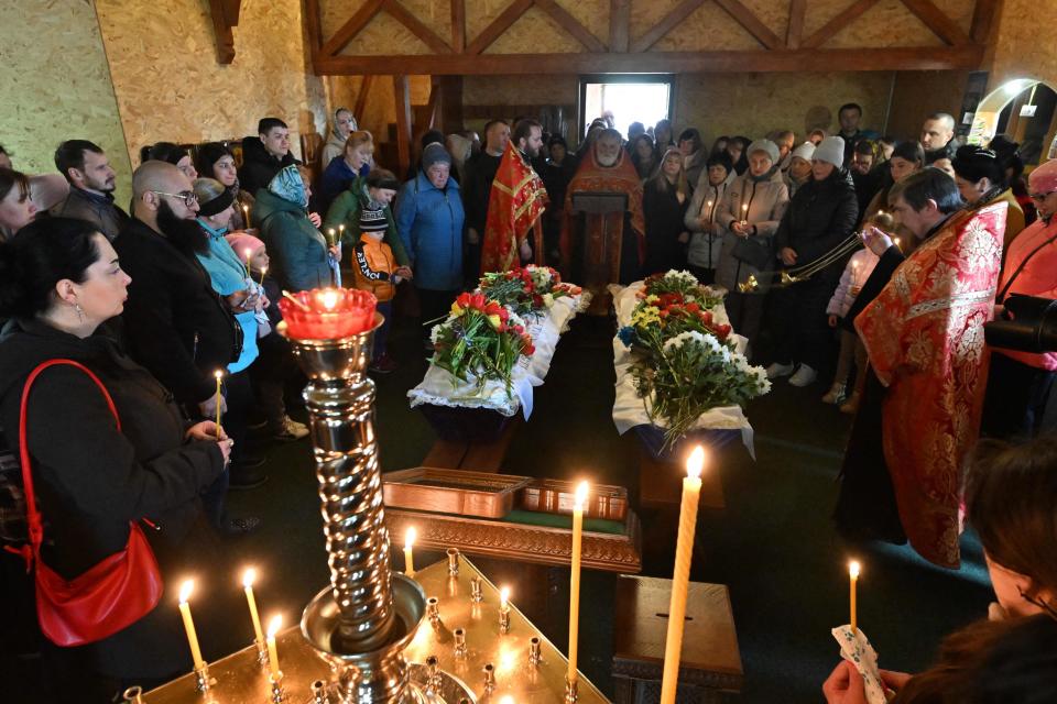 People take part in a funeral service for sister and brother Shulga Sophiya, 11, and Pisarev Kiryusha, 17 (AFP via Getty Images)