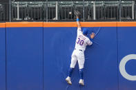 New York Mets center fielder Rafael Ortega trys to catch a two-run home run by Cincinnati Reds' Christian Encarnacion-Strand as it goes into the stands during the eighth inning of a baseball game, Sunday, Sept. 17, 2023, in New York. (AP Photo/Mary Altaffer)