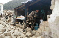 A rescuer looks at a damaged house, after a 7.9 magnitude earthquake hit Nepal, in Xigaze Prefecture, Tibet Autonomous Region, China, April 25, 2015. T REUTERS/Stringer