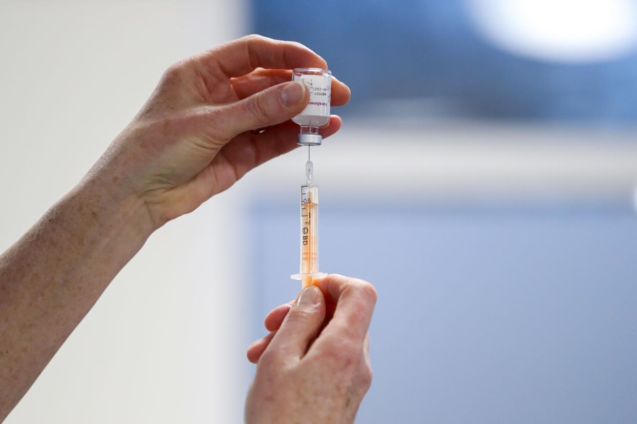 A healthcare worker fills a syringe with a dose of the Oxford/AstraZeneca coronavirus vaccine (POOL/AFP via Getty Images)