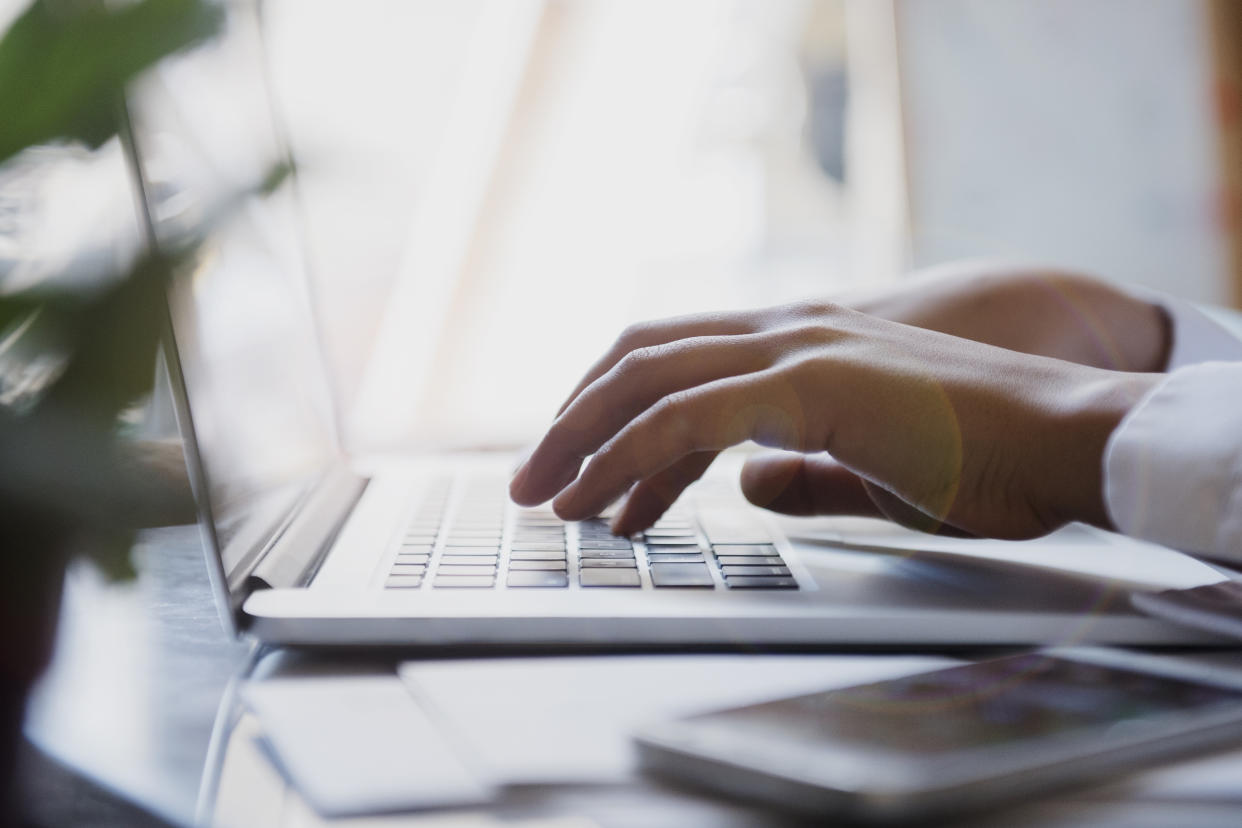 Hands of African American woman typing on laptop