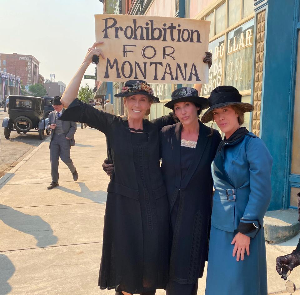 Carey O'Donnell hoists a sign prop between takes on the set of "1923" with her fellow background actors, a group dubbed the "Temperance Women."