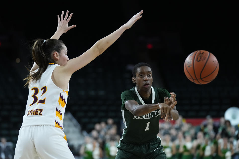 Manhattan guard Dee Dee Davis (1) passes the ball as Iona guard Judith Gomez (32) defends during the first half of an NCAA college basketball game in the championship of the Metro Atlantic Athletic Conference Tournament, Saturday, March 11, 2023, in Atlantic City N.J. (AP Photo/Matt Rourke)