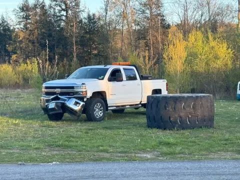 a white truck with a smashed bumper