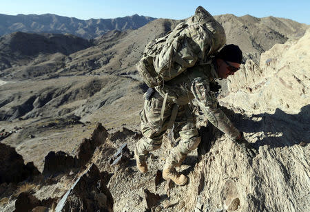 FILE PHOTO: A U.S soldier climbs a hill with a heavy rucksack near the town of Walli Was in Paktika province, near the border with Pakistan, November 4, 2012. Picture taken November 4, 2012. REUTERS/Goran Tomasevic/File Photo