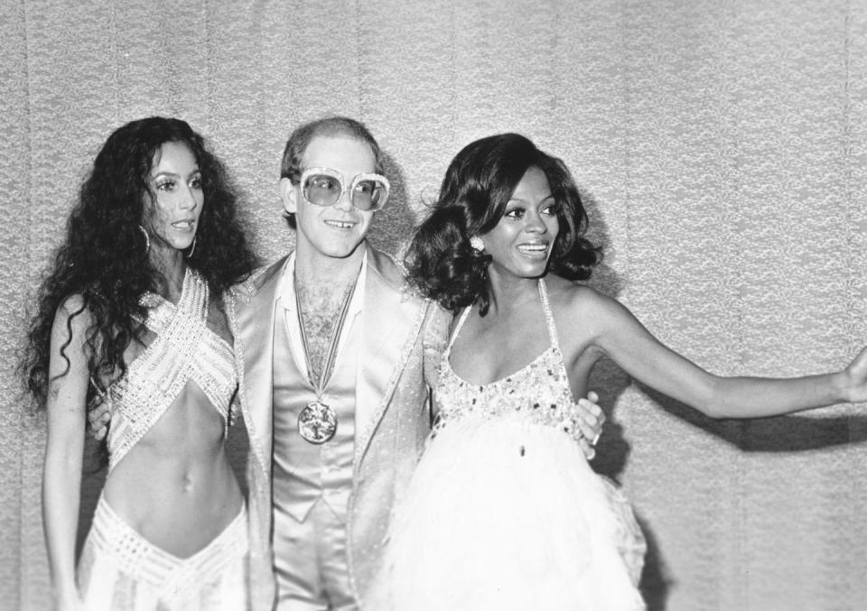 <p>Cher, Elton John, and Diana Ross pose together while backstage at the first Rock Music Awards in Los Angeles in 1975. </p>