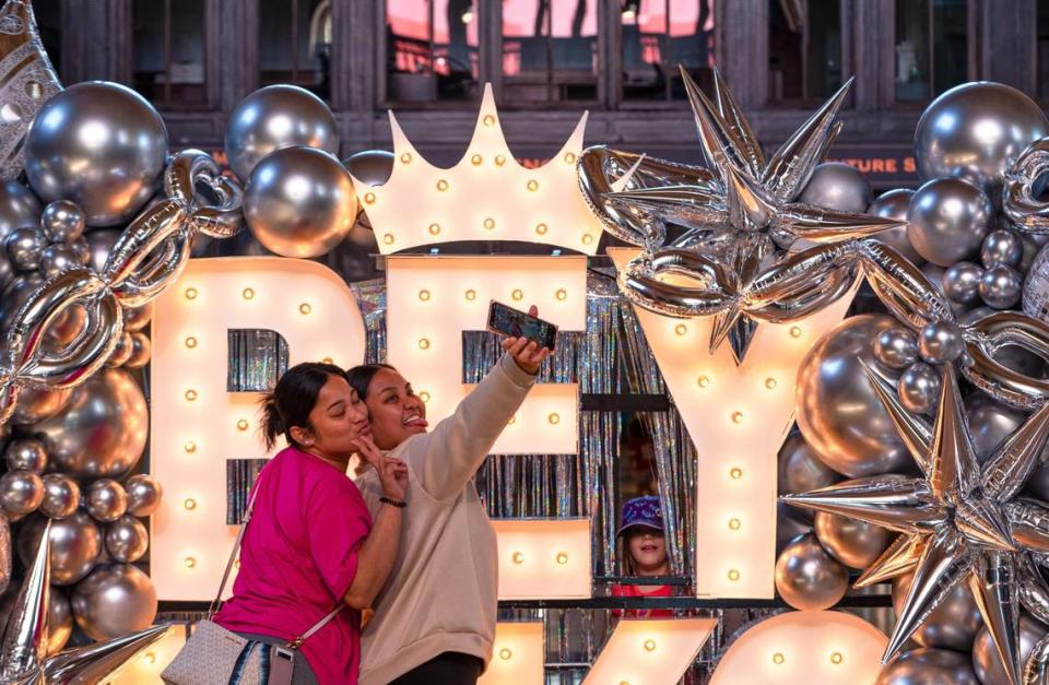 Marina John, left, and Destiny Weilbacher take a selfie in front of the Beyoncé sign on Friday at Union Station. The bright Beyoncé sign stood roughly 7 feet tall and was covered in balloons.