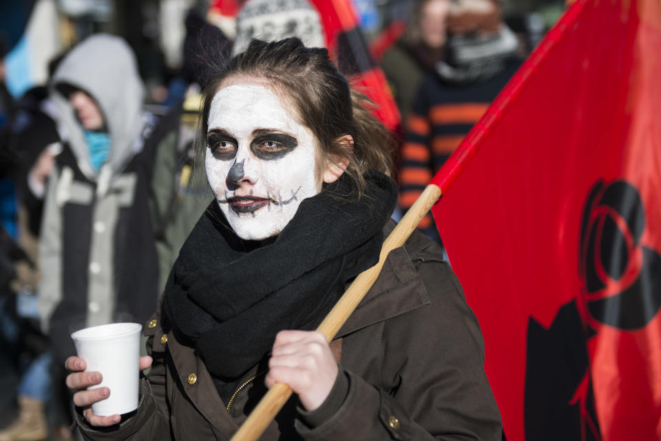 A demonstrator walks in the street with painted face during a protest against the Davos World Economic Forum, WEF, on the side line of the 44. Annual Meeting of the World Economic Forum, WEF, in Davos, Switzerland, Saturday, Jan. 25, 2014. (AP Photo/Keystone,Jean-Christophe Bott)