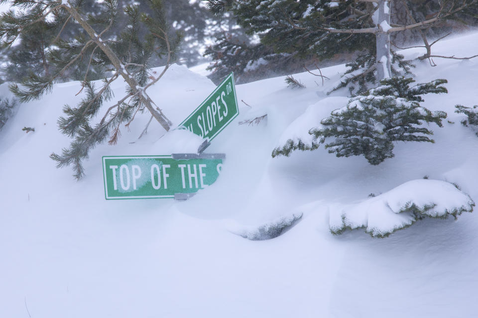 In this photo provided by Mammoth Lakes Tourism, a street sign is covered in snow in Mammoth Lakes, Calif., Sunday, March 3, 2024. A powerful blizzard that closed highways and ski resorts had moved through the Sierra Nevada by early Monday, but forecasters warned that more snow was on the way for the Northern California mountains. (Samantha Lindberg/Mammoth Mountain via AP)