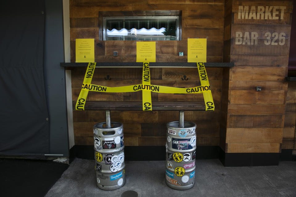 Un banco hecho con barriles de cerveza, precintado para evitar su uso en un bar cerrado temporalmente por la pandemia del coronavirus, en Los Ángeles, el 8 de julio de 2020. (AP Foto/Jae C. Hong)