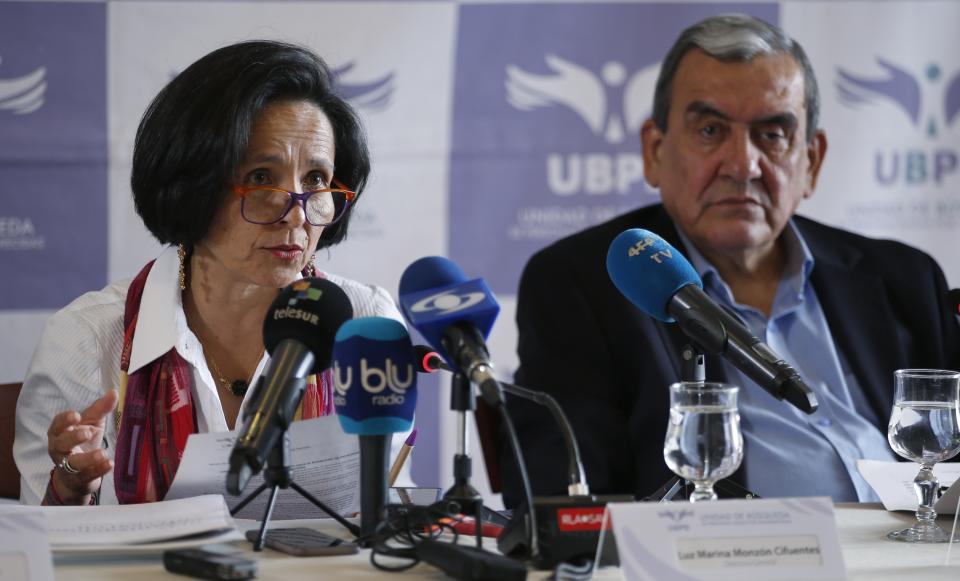 Luz Marina Monzon, director of the missing person's unit, left, and Jaime Alberto Parra, an ex-combatant of the Revolutionary Armed Forces of Colombia, FARC, take part in a presentation on information on those disappeared during the nation's civil conflict, in Bogota, Colombia, Tuesday, Aug. 20, 2019. A special unit tasked by Colombia’s peace process to search for the thousands who disappeared over more than five decades of conflict will analyze the information and work with authorities to try and locate remains. (AP Photo/Fernando Vergara)