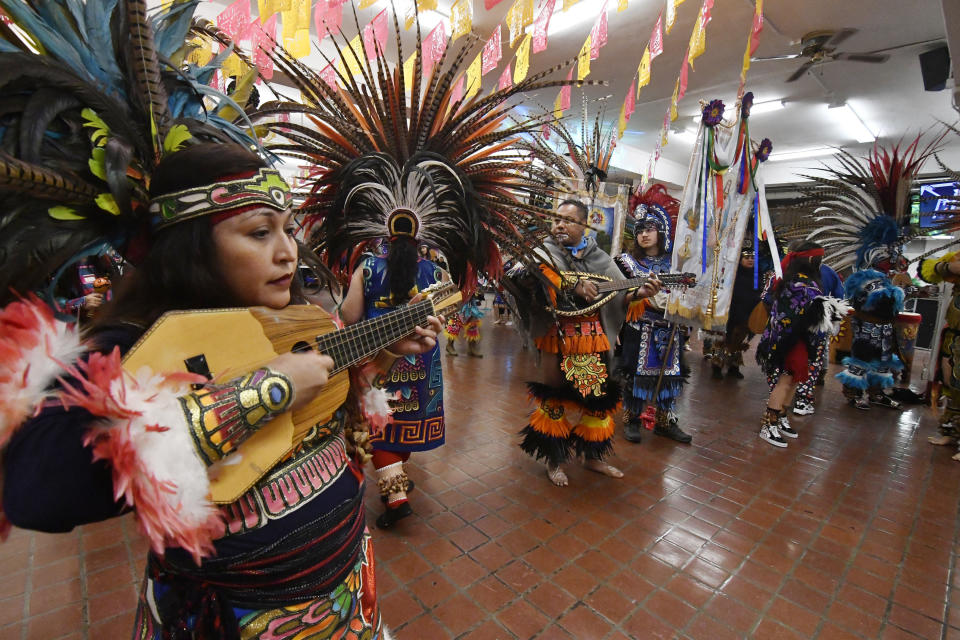 In this Jan. 24, 2020 photo, people in Aztec clothing take part in a dance at the Sagrado Corazon de Jesus church in Minneapolis, for a two-day celebration for the patron saint of the Mexican town of Axochiapan and nearby villages in the state of Morelos. The celebration is a way to recognize their roots and feel closer to the families and home they left behind. (AP Photo/Jim Mone)