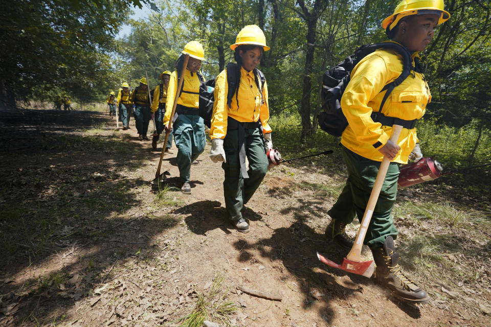 Students make their way through a forrest during a wildland firefighter training Friday, June 9, 2023, in Hazel Green, Ala. A partnership between the U.S. Forest Service and four historically Black colleges and universities is opening the eyes of students of color who had never pictured themselves as fighting forest fires. (AP Photo/George Walker IV)