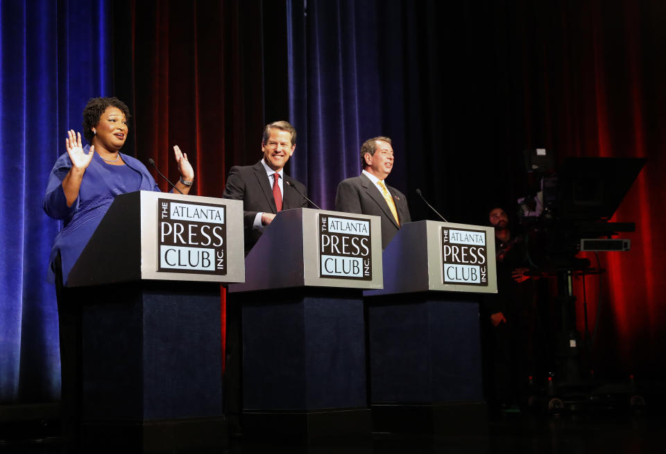 Gubernatorial candidates for Georgia, from left, Democrat Stacey Abrams, Republican Secretary of State Brian Kemp and Libertarian Ted Metz react as a fire alarm interrupts a debate Tuesday, Oct. 23, 2018, in Atlanta. (AP Photo/John Bazemore, Pool)