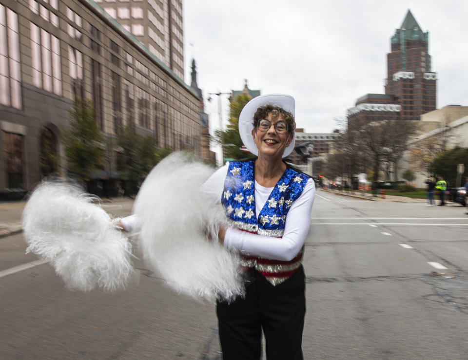Jan Kwiatkowski, a co-leader of the Milwaukee Dancing Grannies, smiles and swings pompoms as she marches in the Veterans’ Day parade in Milwaukee on Saturday, Nov. 5, 2022. Kwiatkowski, 67, is a family therapist and ordained chaplain who has been a Dancing Granny since 2018. She offered to help lead the group as they have regrouped and rebuilt in the face of tragedy. Three Dancing Grannies and one group member’s husband were among those killed at a Christmas parade last November in Waukesha, Wis., when the driver of an SUV struck them on the parade route. Dozens more, including some Grannies, were injured. The Grannies plan to perform at this year’s parade with a vow to remain “Granny Strong!” (AP Photo/Kenny Yoo)