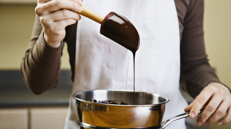 Person, spatula, and melted chocolate