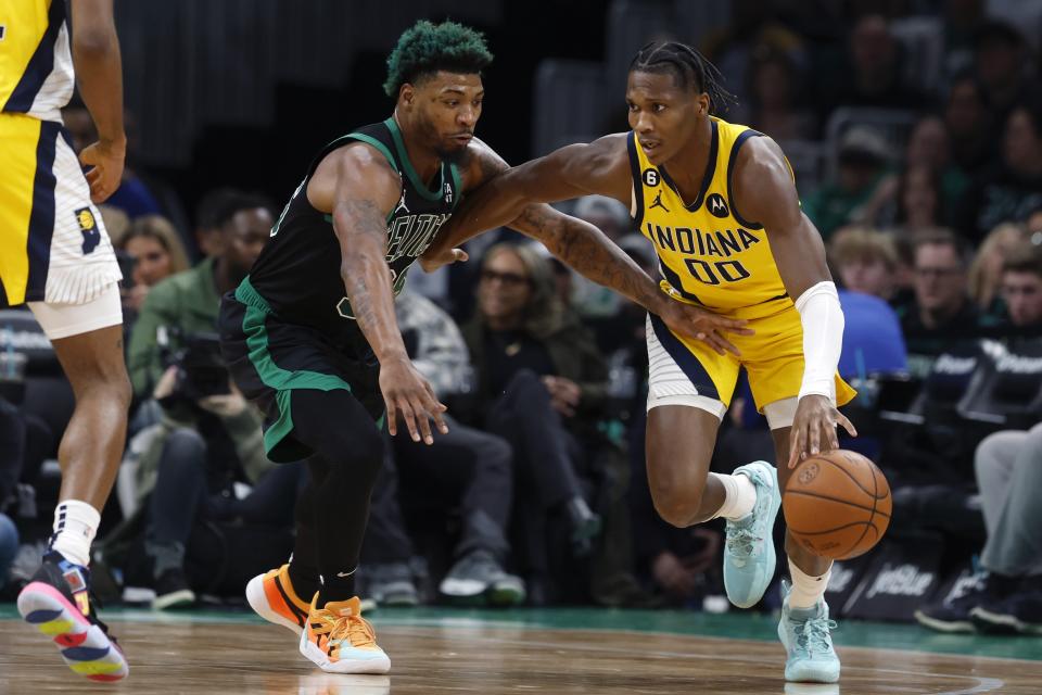 Indiana Pacers' Bennedict Mathurin (00) drives past Boston Celtics' Marcus Smart during the first half of an NBA basketball game Friday, March 24, 2023, in Boston. (AP Photo/Michael Dwyer)