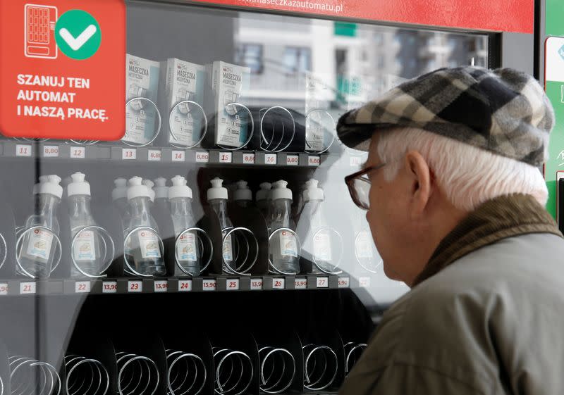 A man looks at a vending machine for face masks, gloves and sanitiser during the coronavirus disease (COVID-19) outbreak, in Warsaw