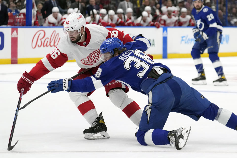 Detroit Red Wings defenseman Jake Walman (96) takes down Tampa Bay Lightning left wing Brandon Hagel (38) during the second period of an NHL hockey game Thursday, April 13, 2023, in Tampa, Fla. (AP Photo/Chris O'Meara)