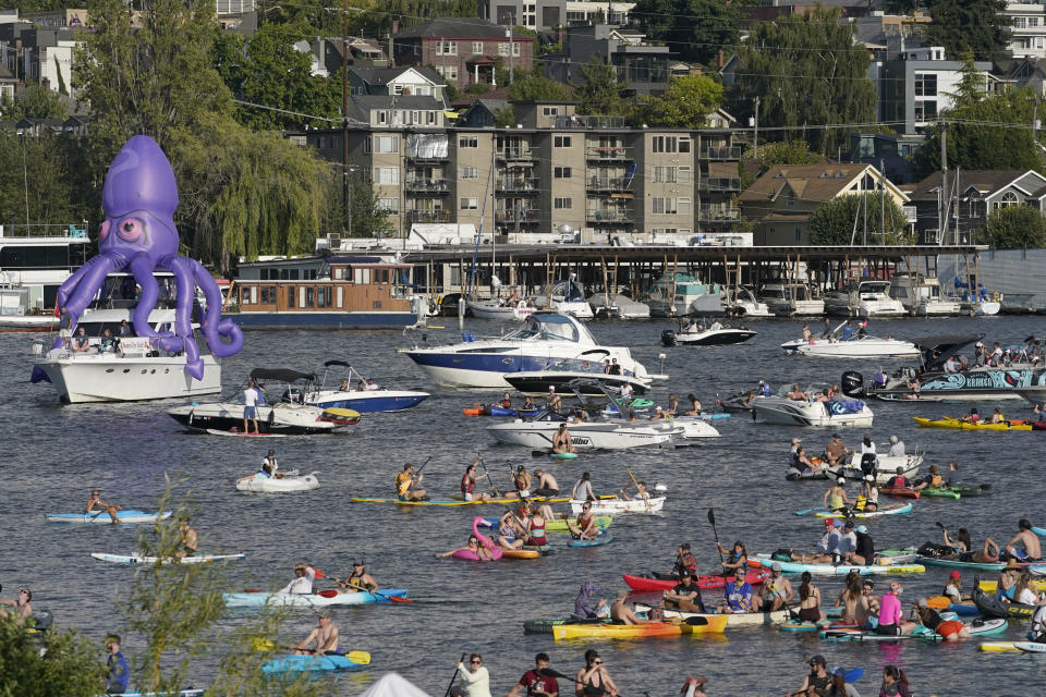 Fans on kayaks and boats, including one sporting a giant inflatable octopus, float on Lake Union, Wednesday, July 21, 2021, during the Seattle Kraken's NHL hockey expansion draft event in Seattle. (AP Photo/Ted S. Warren)