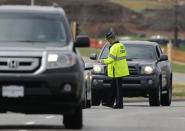 A Kansas State Trooper controls traffic at the entrance of the Jewish Community Center after reports of a shooting in Overland Park, Kan., Sunday, April 13, 2014. (AP Photo/Orlin Wagner)