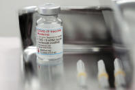 FILE - In this June 14, 2021, file photo, a vital of the Moderna COVID-19 vaccine that is being administered for flight attendants of Japan Airlines at Haneda Airport as the airline company began its workplace vaccination, in Tokyo. An array of major retailers, automakers and trading companies have started providing Moderna Inc. shots distributed by the government for free for their employees and families. After months of delays due to political and bureaucratic bungling as well as a shortage of vaccines, inoculations in Japan are taking off, and the drive is now racing down to the wire with the Olympics starting in one month. (AP Photo/Eugene Hoshiko, File)