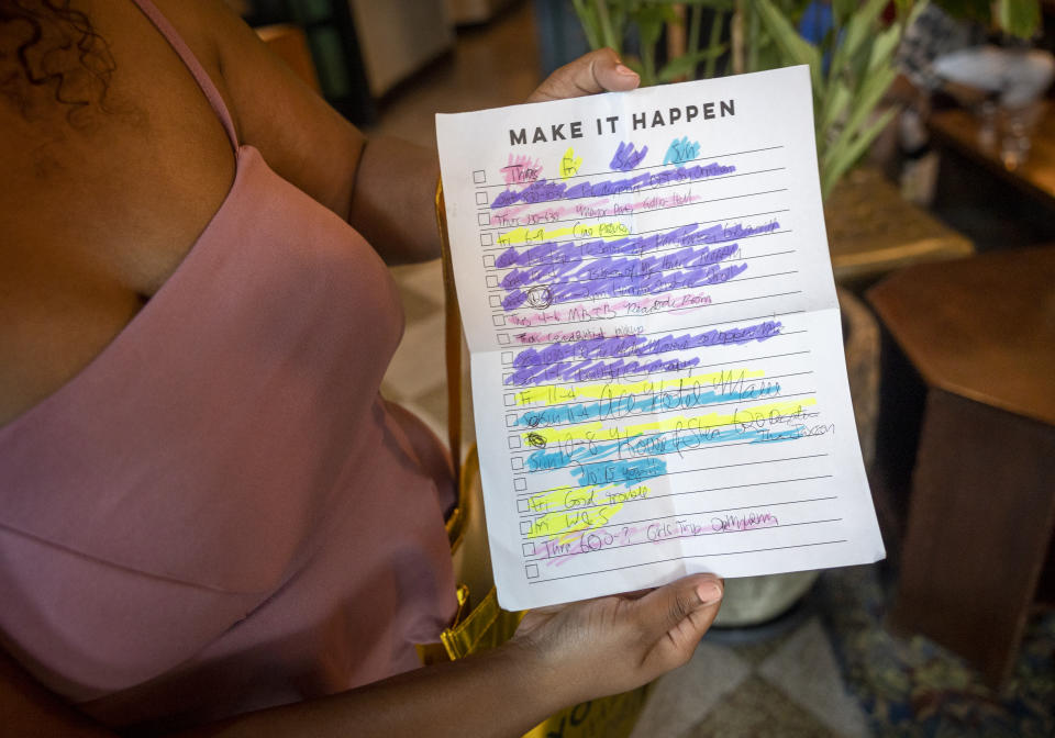 Megan Braden-Perry holds the handwritten schedule she made helping her divide the parties and shows she plans to go to during Essence Fest in downtown New Orleans on Thursday, June 30, 2022. Essence's chief executive officer said she's been asked a multitude of times whether the Essence Festival of Culture is staying in New Orleans. On Thursday, Caroline Wanga ended any speculation, making the answer to that question very clear.(Chris Granger/The Times-Picayune/The New Orleans Advocate via AP)